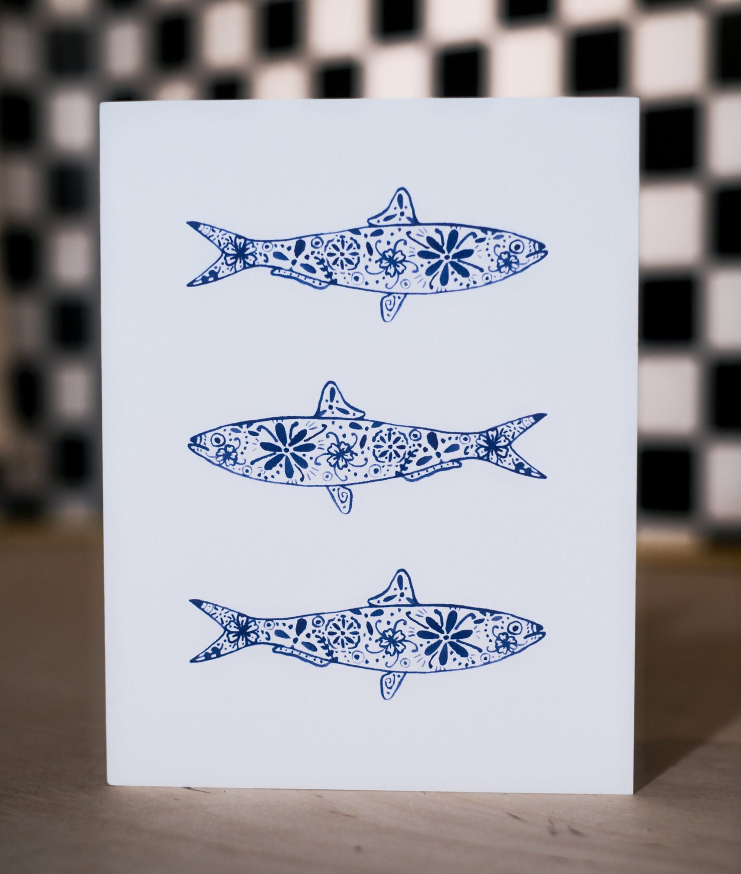Card with blue fish illustrations on a checkered background