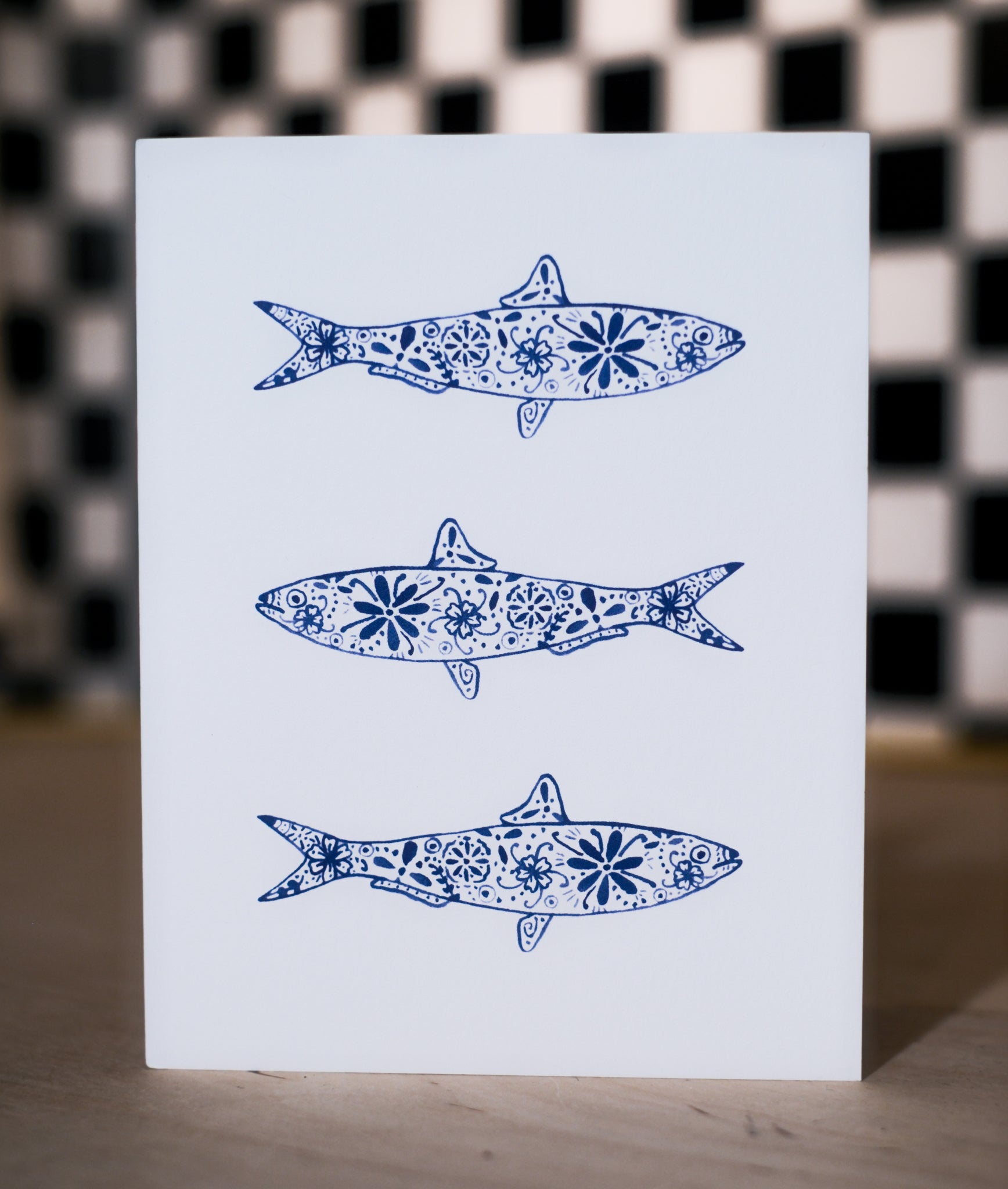 Card with blue fish illustrations on a checkered background