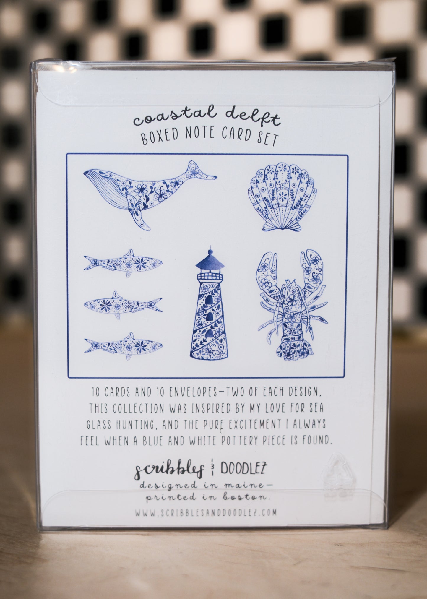 Boxed note card set with coastal design on a checkered background