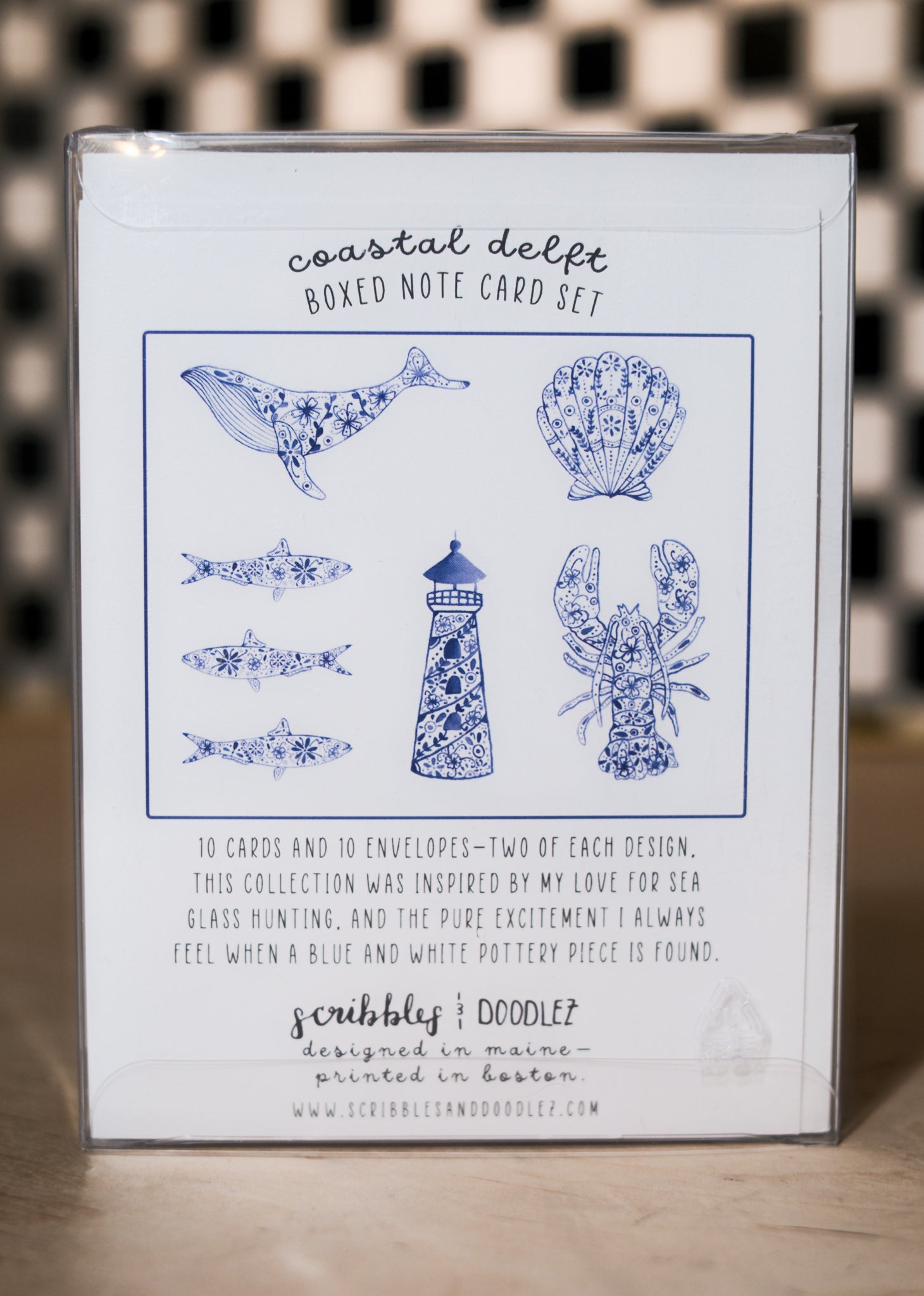 Boxed note card set with coastal design on a checkered background