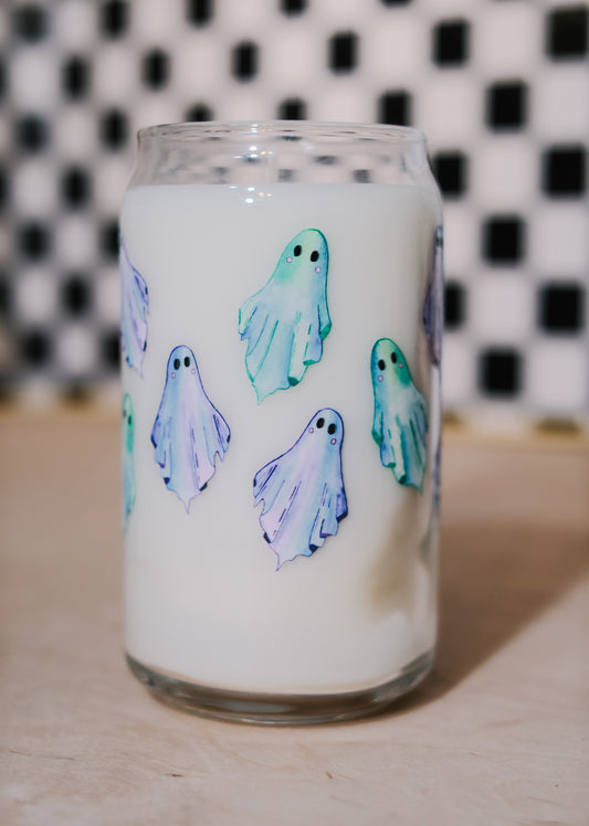 Glass tumbler filled with soy wax with ghost designs on a checkered background