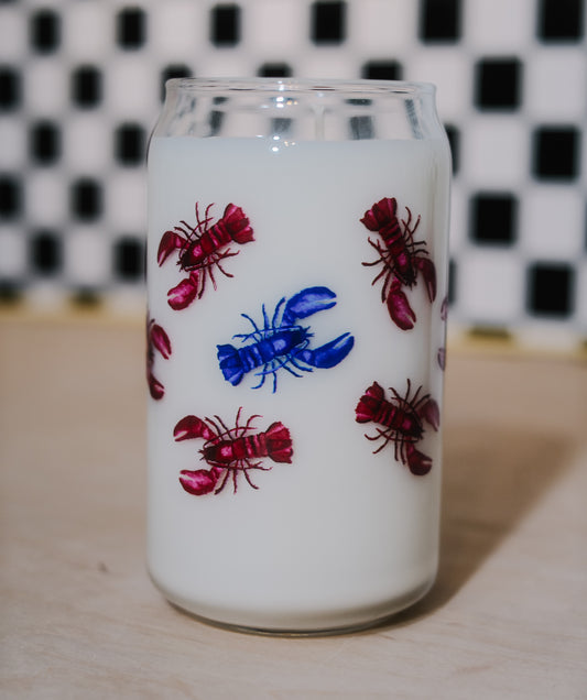 soy wax filled glass can with red and blue lobster illustrations on a checkered background