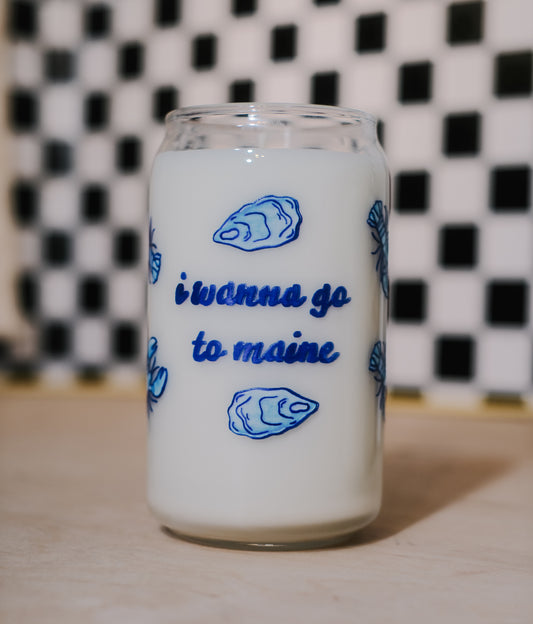 Glass container filled with scented soy wax and blue text 'i wanna go to maine' on a checkered background.