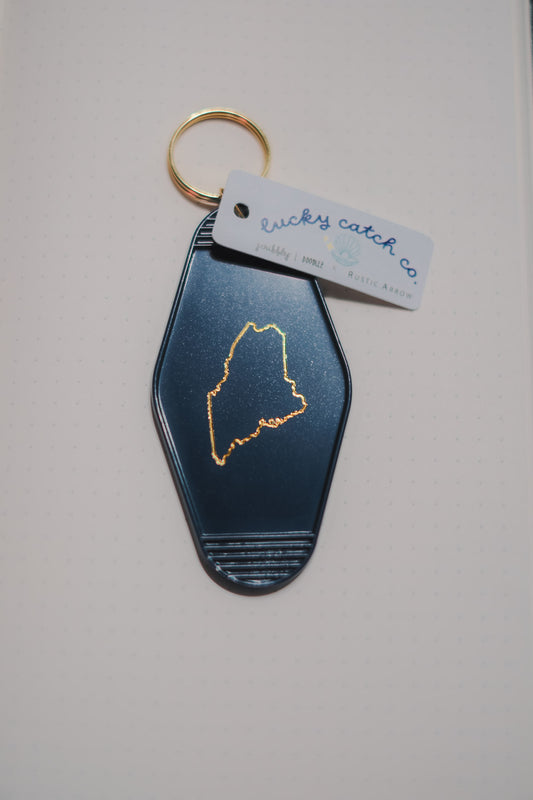 Keychain with Maine outline design on a light gray background
