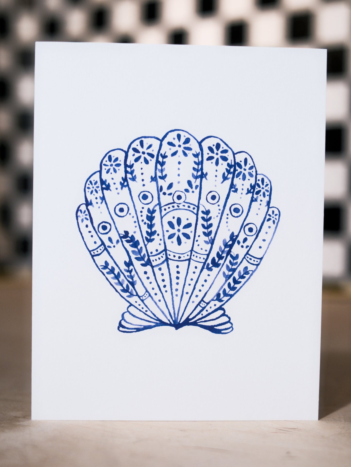 Card with a blue decorative shell design on a white background
