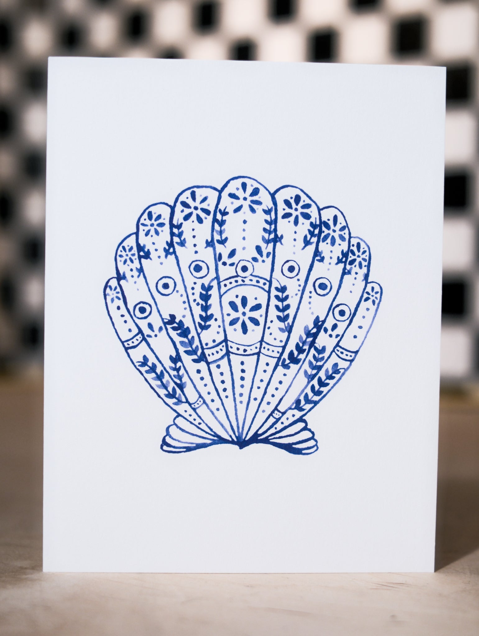 Card with a blue decorative shell design on a white background