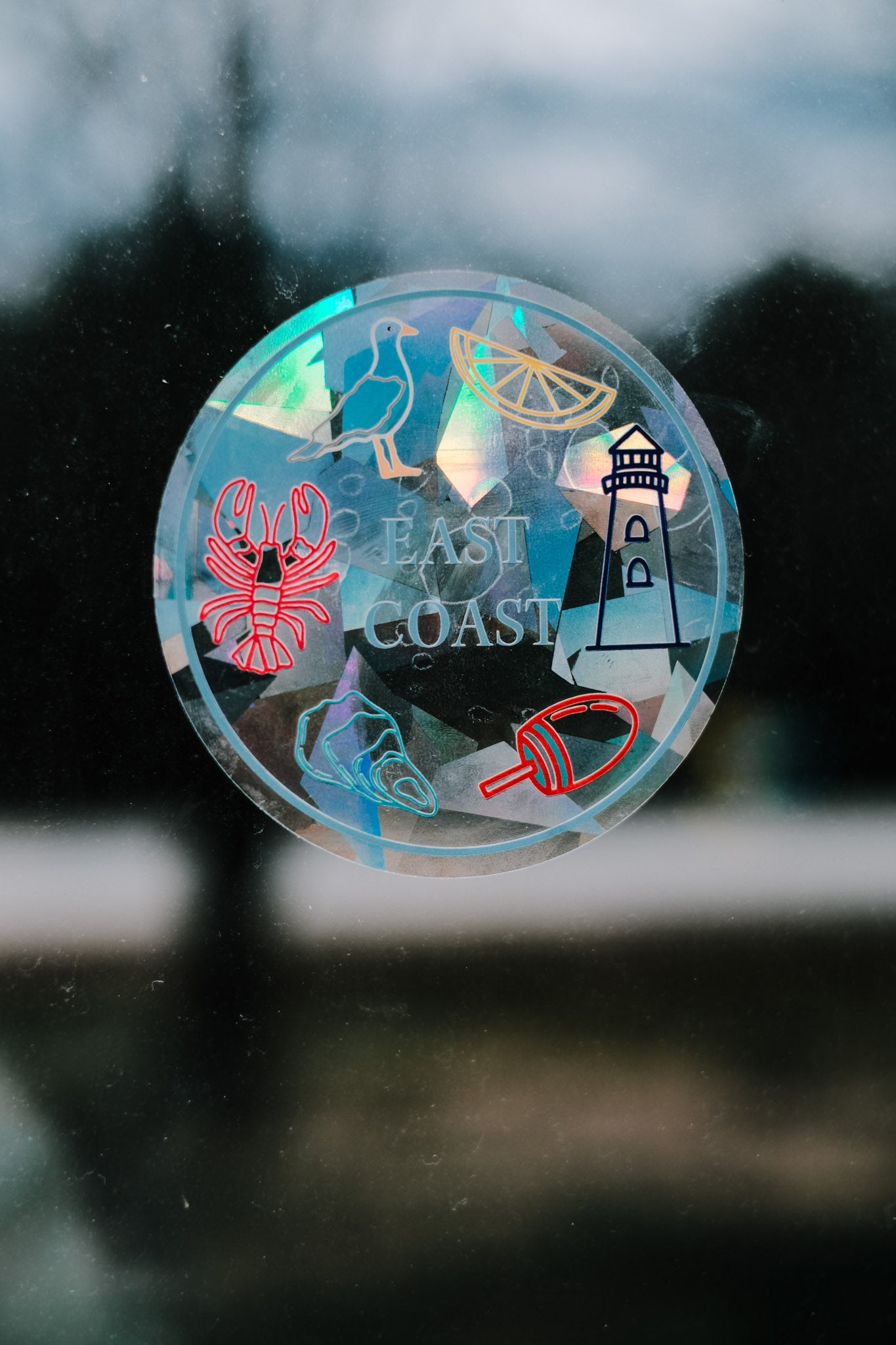 Circular sticker with coastal designs on a glass surface