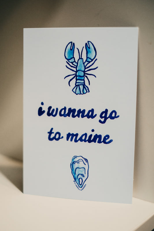 a 4 x 6 inch postcard that is light blue in color. featuring a watercolor blue lobster on top, in the middle in dark blue 'i wanna go to maine' and underneath a blue oyster.