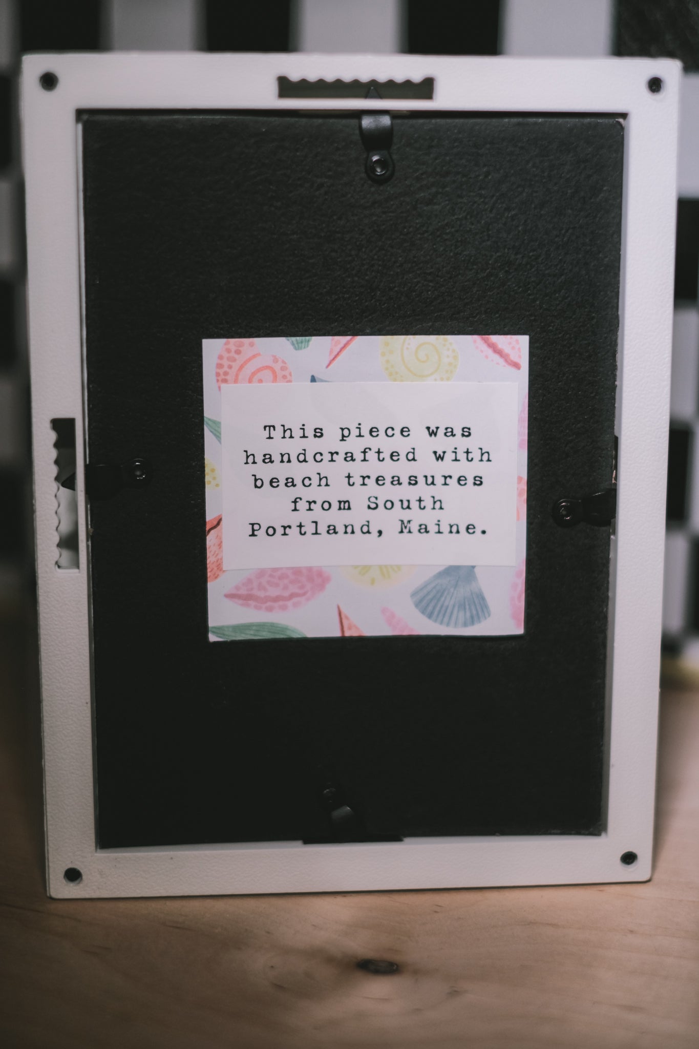 Black frame with a label on a wooden surface